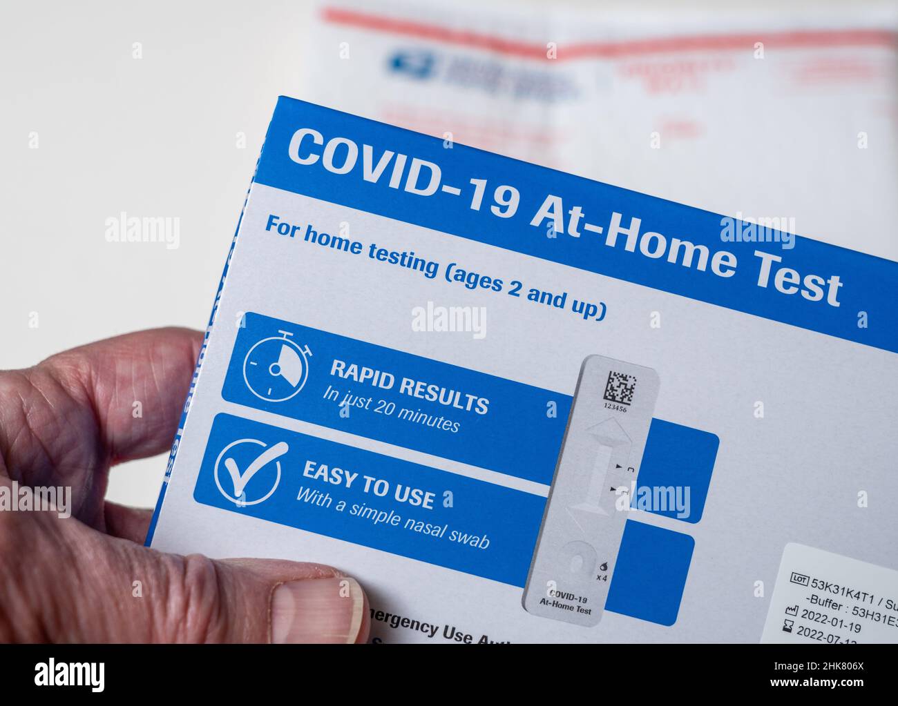 Morgantown, WV - 2 février 2022 : homme senior ouvrant le test à domicile fourni par le gouvernement fédéral pour Covid-19 avec enveloppe du service postal des États-Unis Banque D'Images