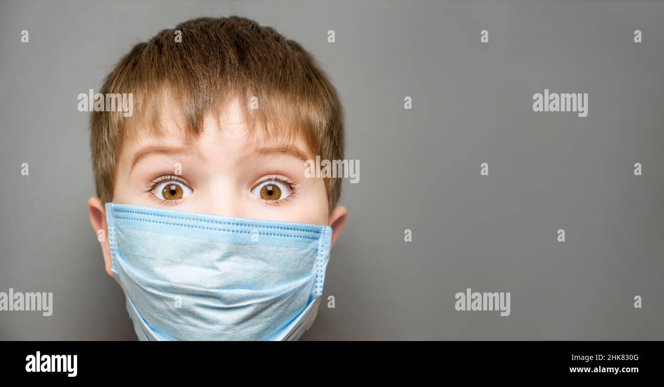 Vaccination des enfants Covid 19, bannière.Enfant surpris garçon portant le masque enfant choqué yeux grand ouverts.Les yeux ouverts ont surpris l'enfant dans le masque de visage enfant Banque D'Images