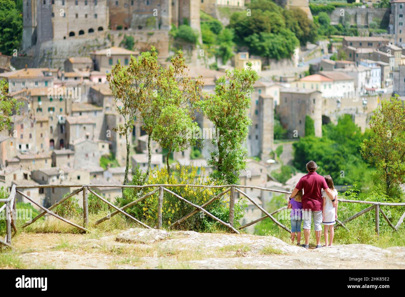 Famille de trois personnes bénéficiant de la vue sur Sorano, une ancienne ville médiévale de colline suspendue d'une pierre de tuf sur la rivière lente.Patrimoine étrusque.Province Banque D'Images