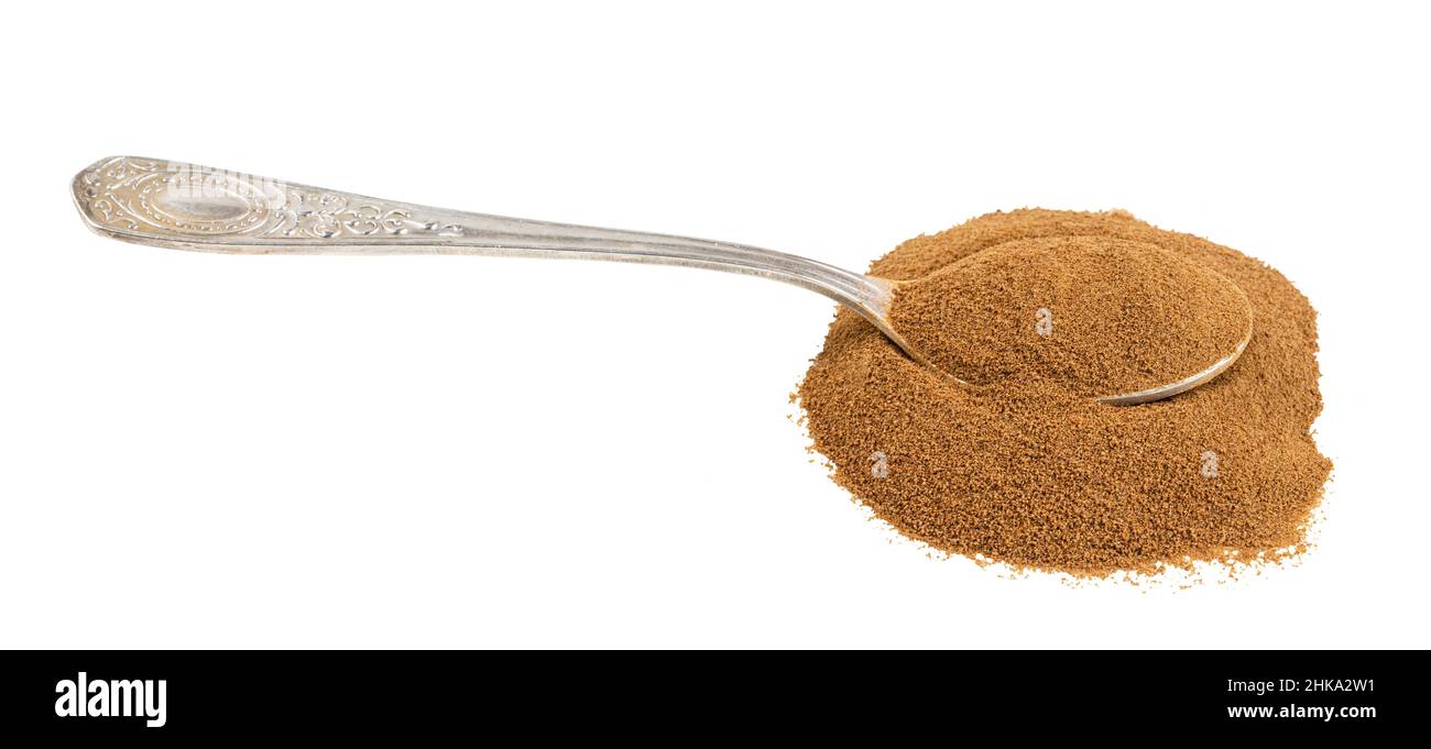 cuillère d'argent avec poudre de racine de chicorée rôtie soluble dans un tas isolé sur fond blanc Banque D'Images