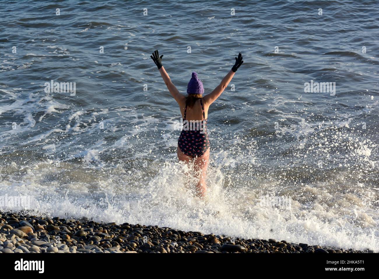 Une femme d'eau froide natation d'hiver mer natation Amroth plage Pembrokeshire en janvier Banque D'Images