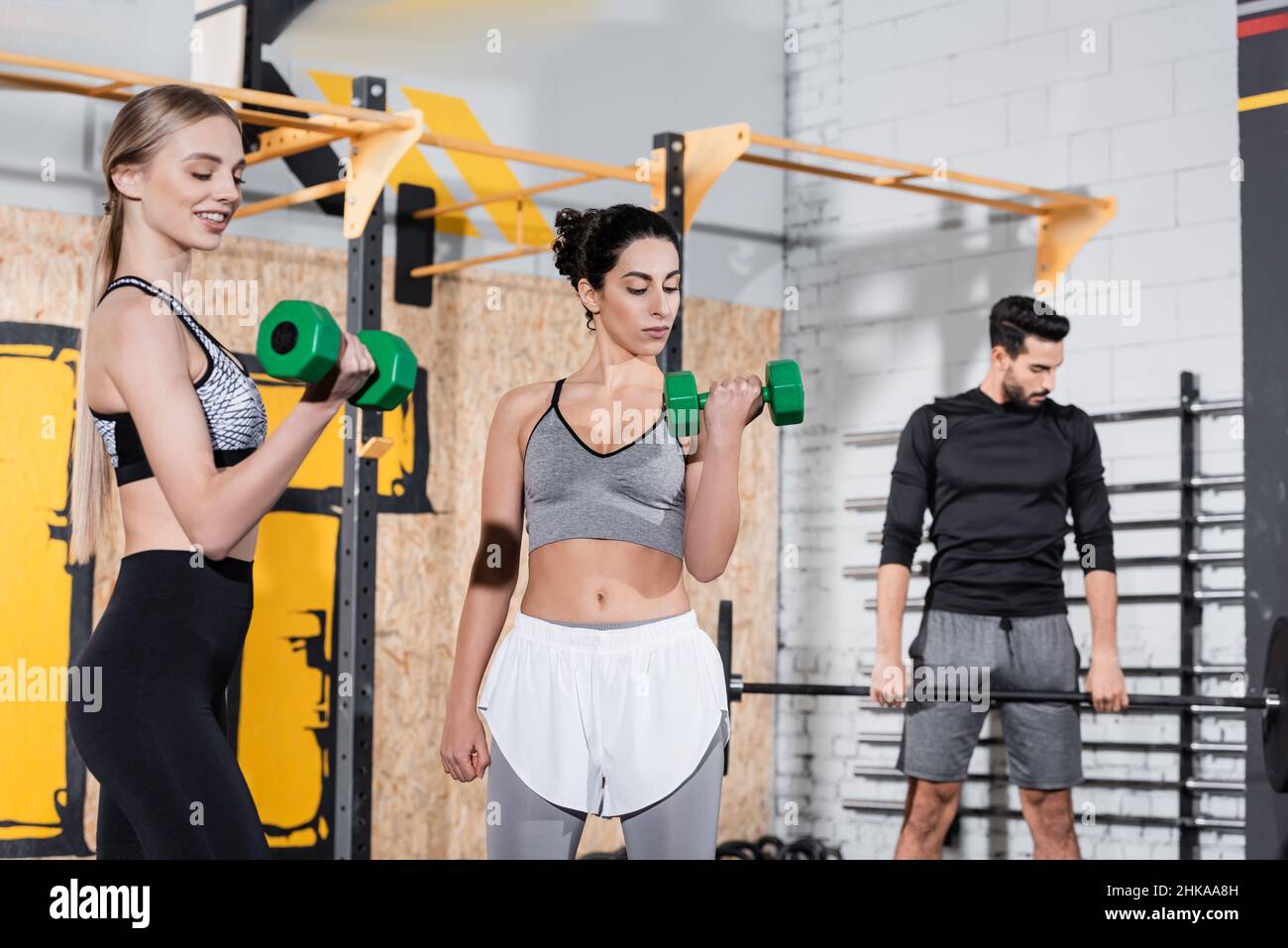 Entraînement multiethnique de sportswomen avec haltères dans la salle de gym Banque D'Images