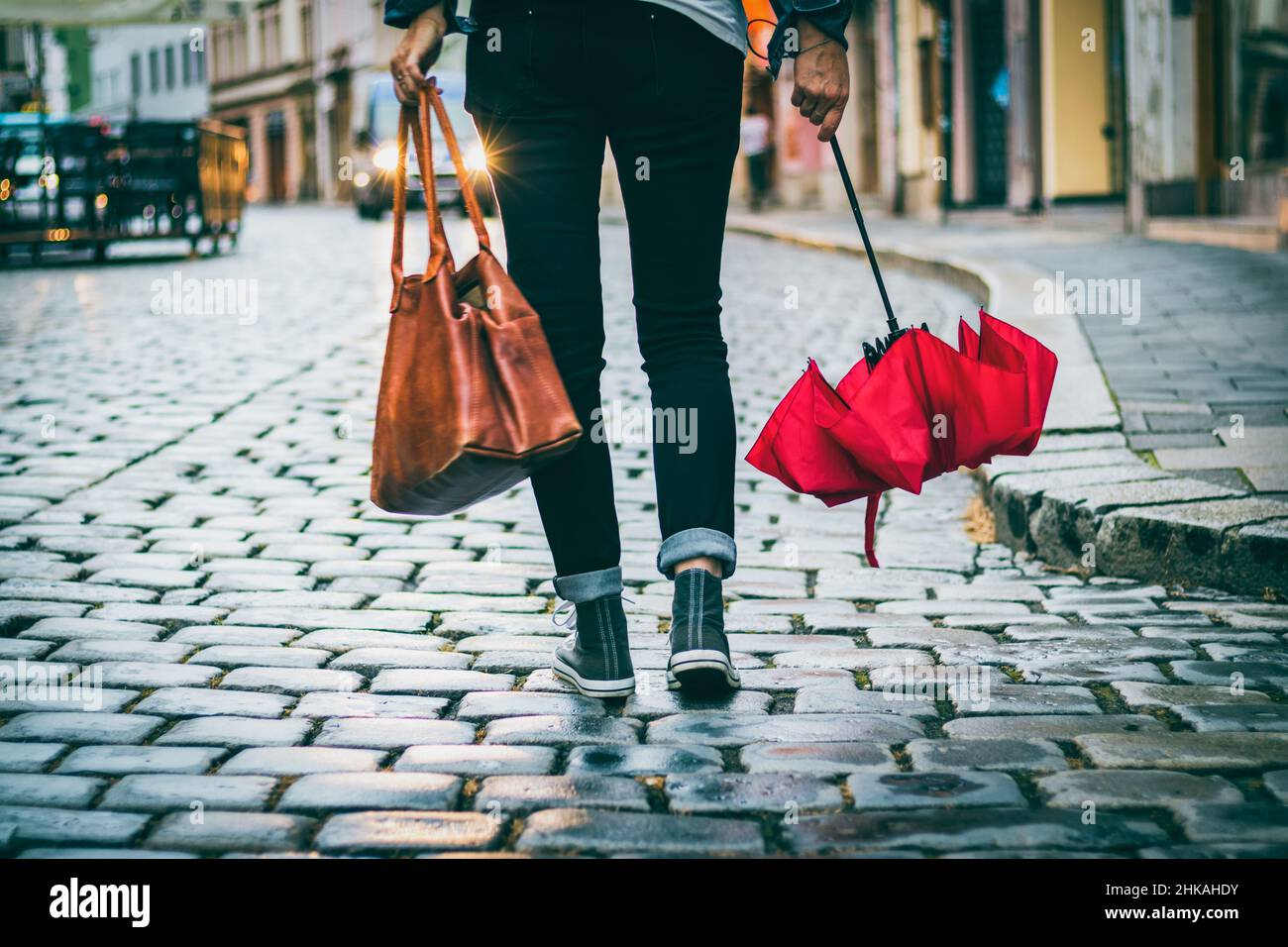 Une femme avec un parapluie et un sac à main va de l'autre côté de la  rue.Marche dans la ville après la pluie.Fille portant des vêtements  décontractés Photo Stock - Alamy