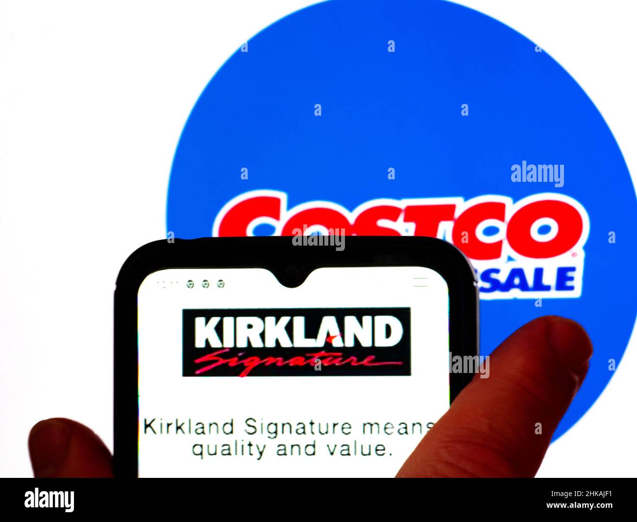 Dans cette illustration, le logo Kirkland Signature est affiché sur l'écran d'un smartphone avec un logo Costco Wholesale Corporation en arrière-plan. Banque D'Images