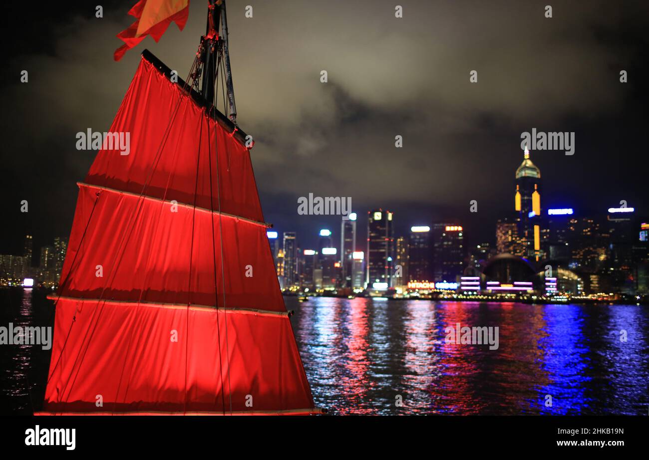 Une jonque rouge chinoise avec vue nocturne sur le port de victoria à Hong kong Banque D'Images
