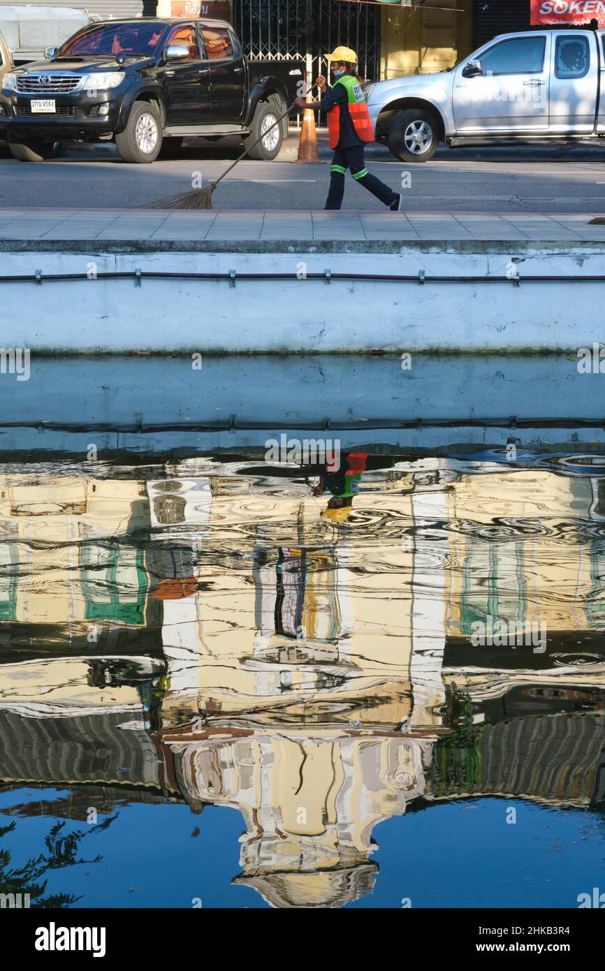 Réflexions d'un ancien bâtiment de style européen à Klong (canal) Lod le long de Atsadang Rd à Bangkok, en Thaïlande, un balai de rue sur la rue ci-dessus Banque D'Images