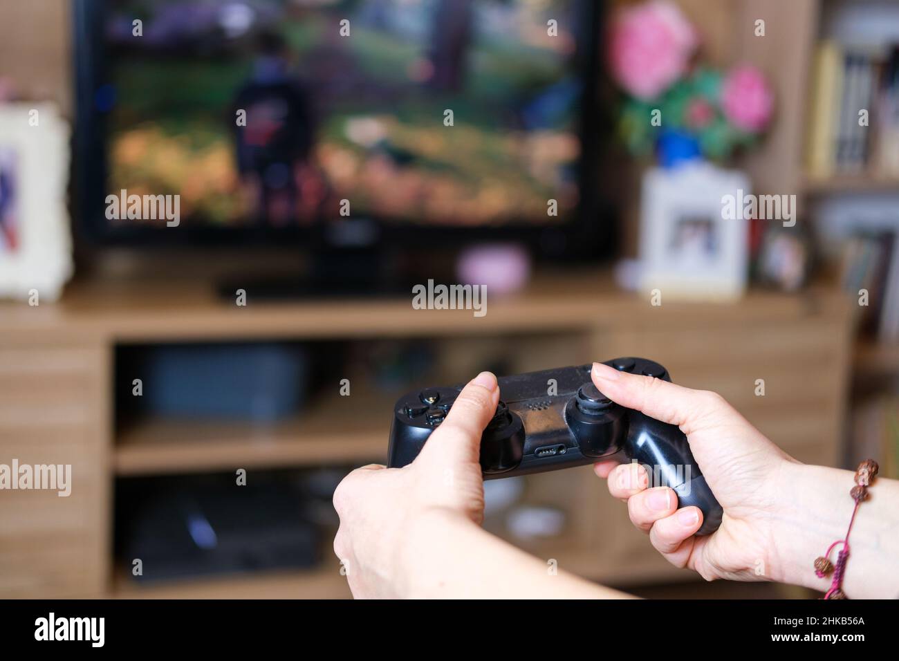 Femme jouant jeu de console, jeu vidéo addiction concept.Gros plan sur les mains des gamers féminins tenant le joystick de console et jouant au jeu vidéo à la maison. Banque D'Images