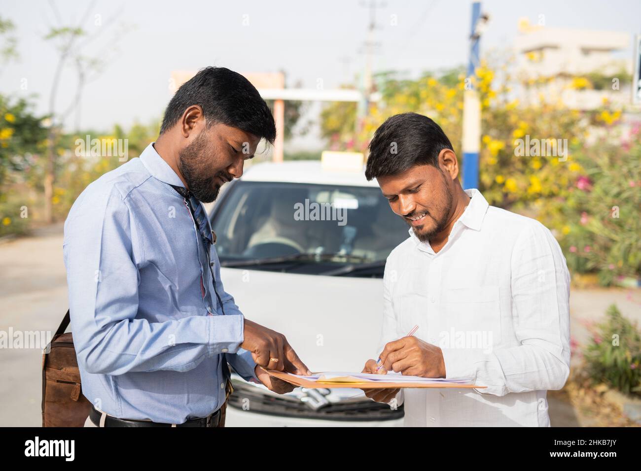 chauffeur de taxi signant sur les documents d'assurance ou de contrat de prêt devant la voiture - approbation de concept de prêt vehical ou personnel, auto-emploi et Banque D'Images