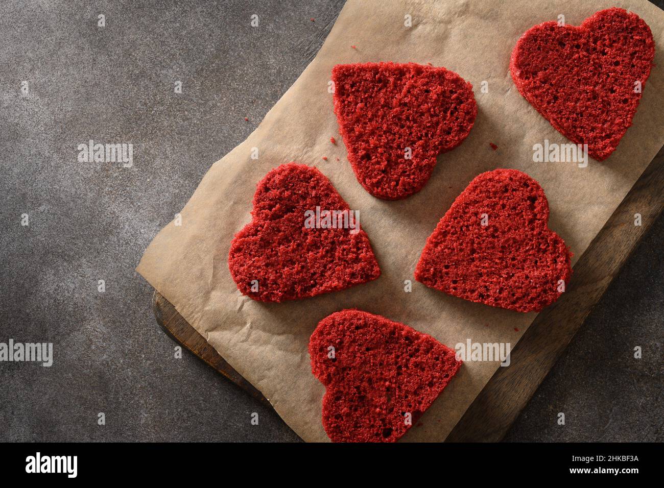 Cuisson de gâteau en velours rouge en forme de coeur pour la Saint-Valentin sur fond sombre.Délicieux dessert maison.Vue de dessus. Banque D'Images