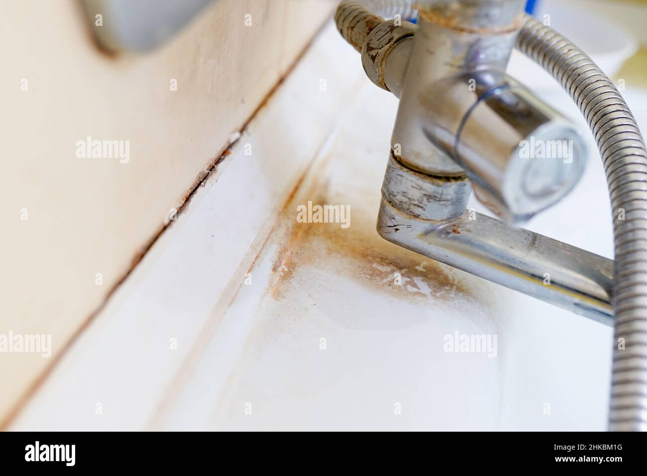 Vieux lavabo sale avec taches de rouille, de calcaire et de savon dans la salle de bains avec un robinet, un robinet d'eau. Banque D'Images