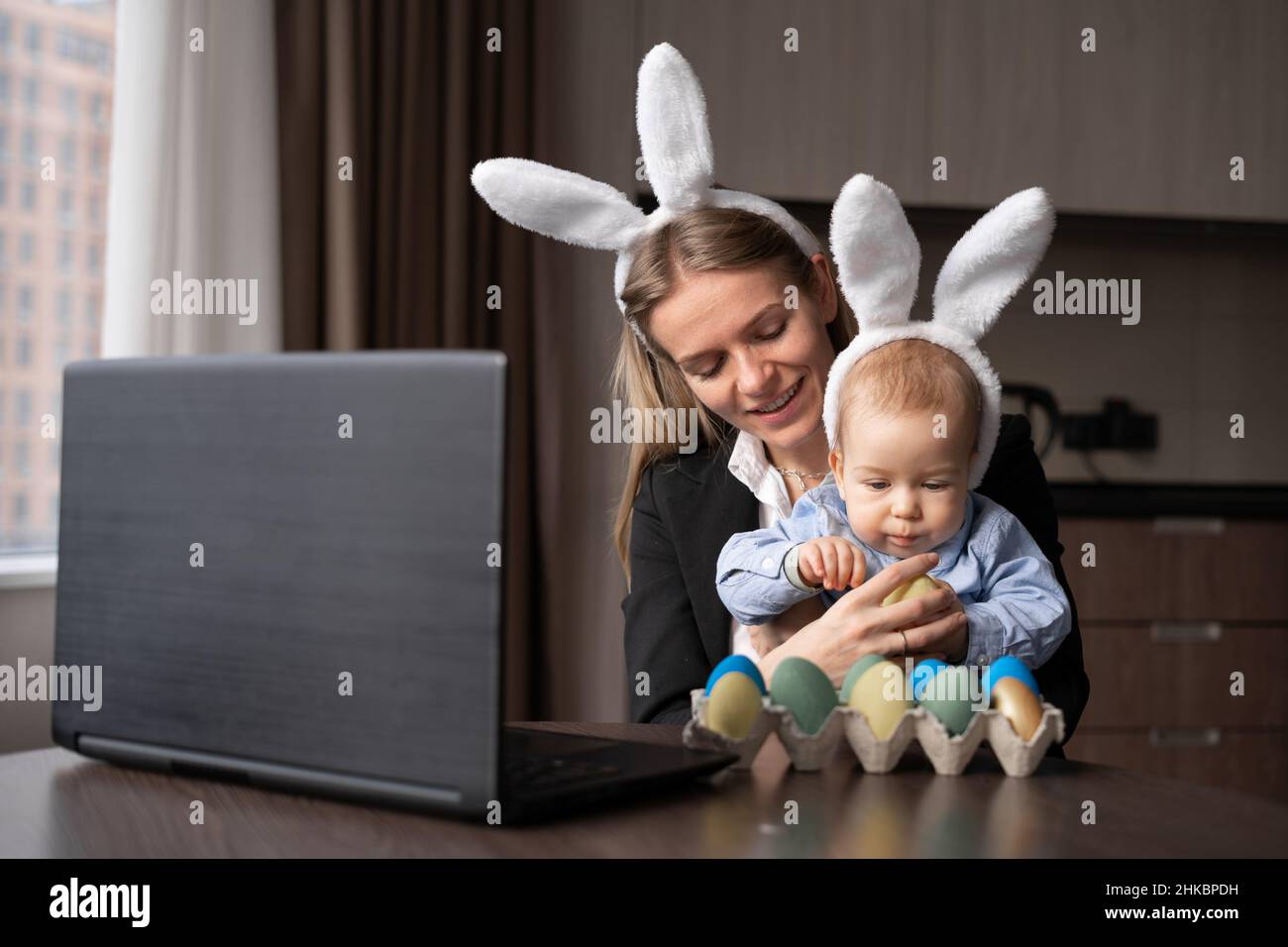 Une femme et un enfant peignent des œufs pour Pâques, enregistrez des leçons sur une webcam avec un ordinateur portable. Banque D'Images