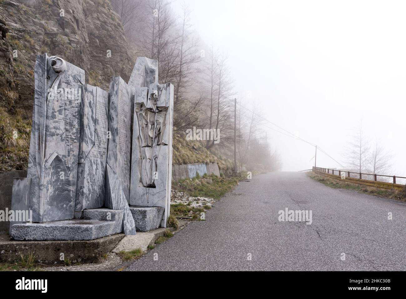 Route de montagne à Alpi Apuane, Italie, œuvres d'art en marbre/monument sur le côté de la route et route nuageux devant vous. Banque D'Images