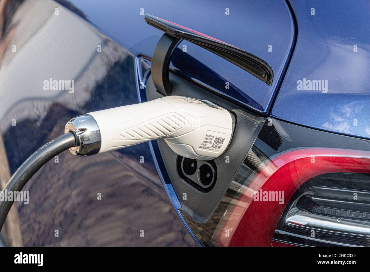 Un câble d'alimentation de charge branché à une voiture Tesla Banque D'Images