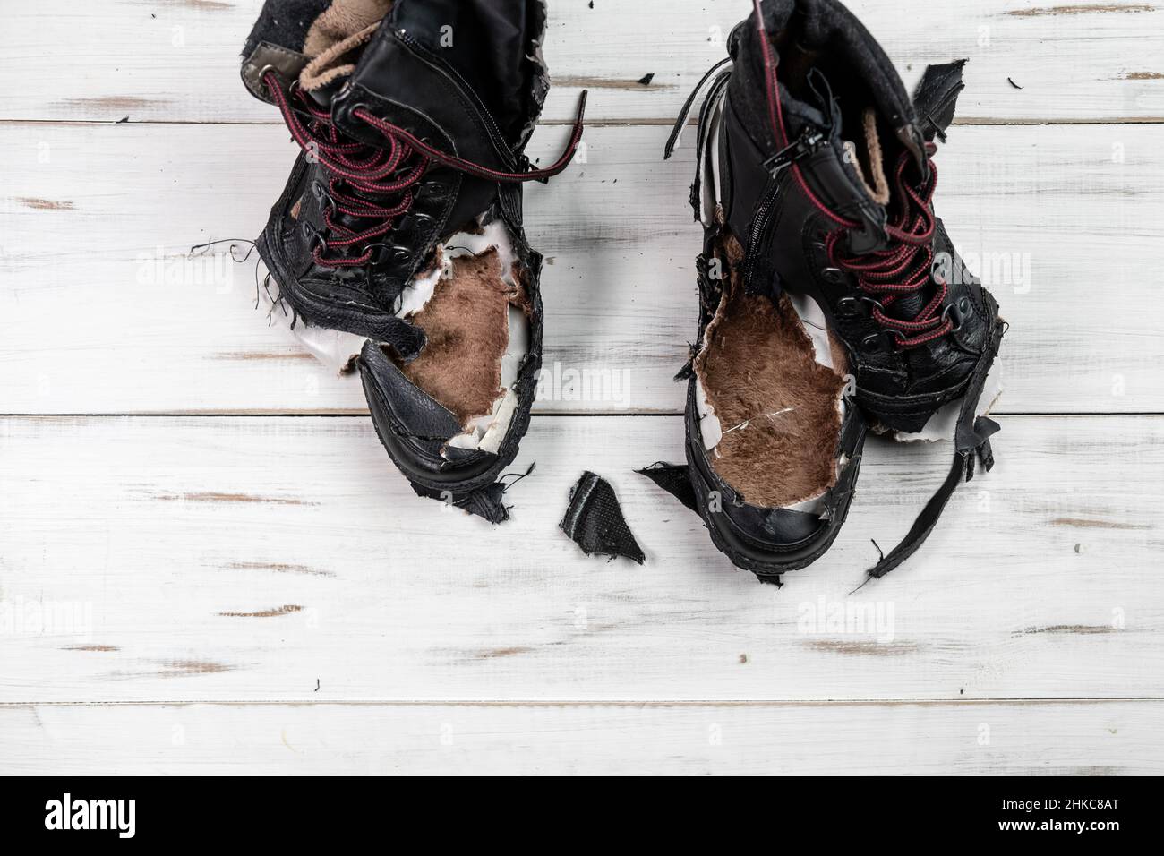 Chaussures usées déchirées bottes.Arrière-plan en bois clair.Chaussures  déchirées et cassées Photo Stock - Alamy