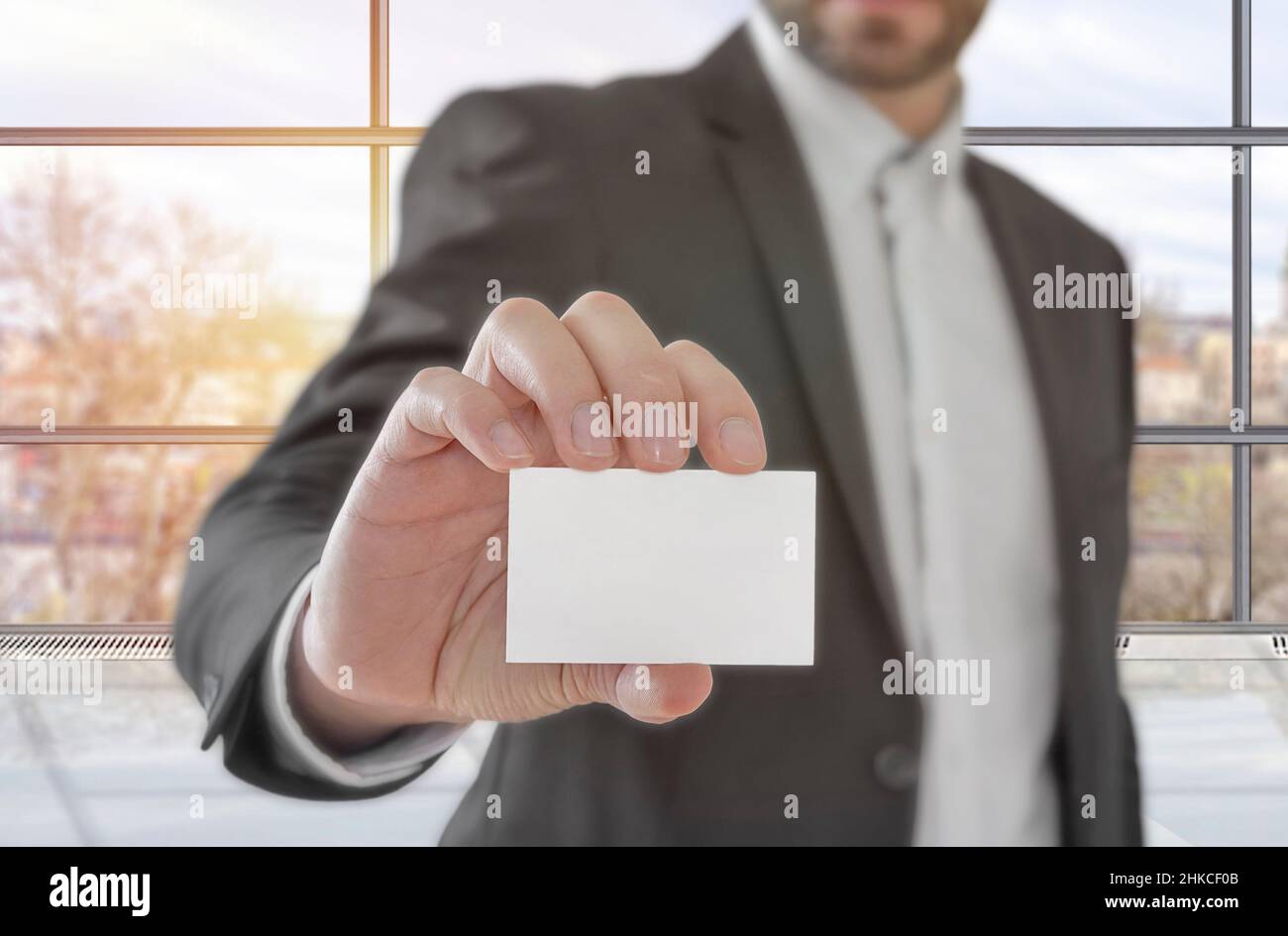 Homme d'affaires tenant une carte de visite en papier blanc au bureau Banque D'Images