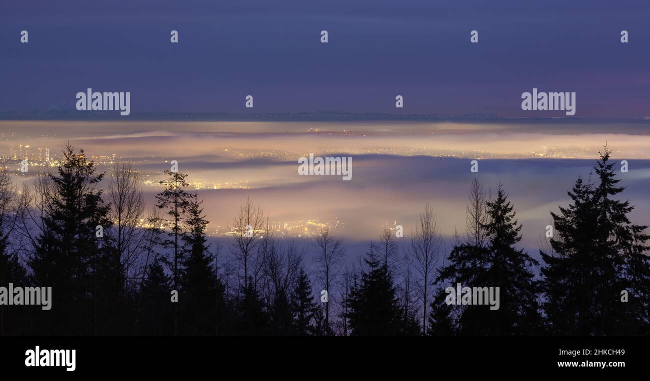 Brouillard recouvrant la ville moderne pendant le crépuscule hivernal. Banque D'Images