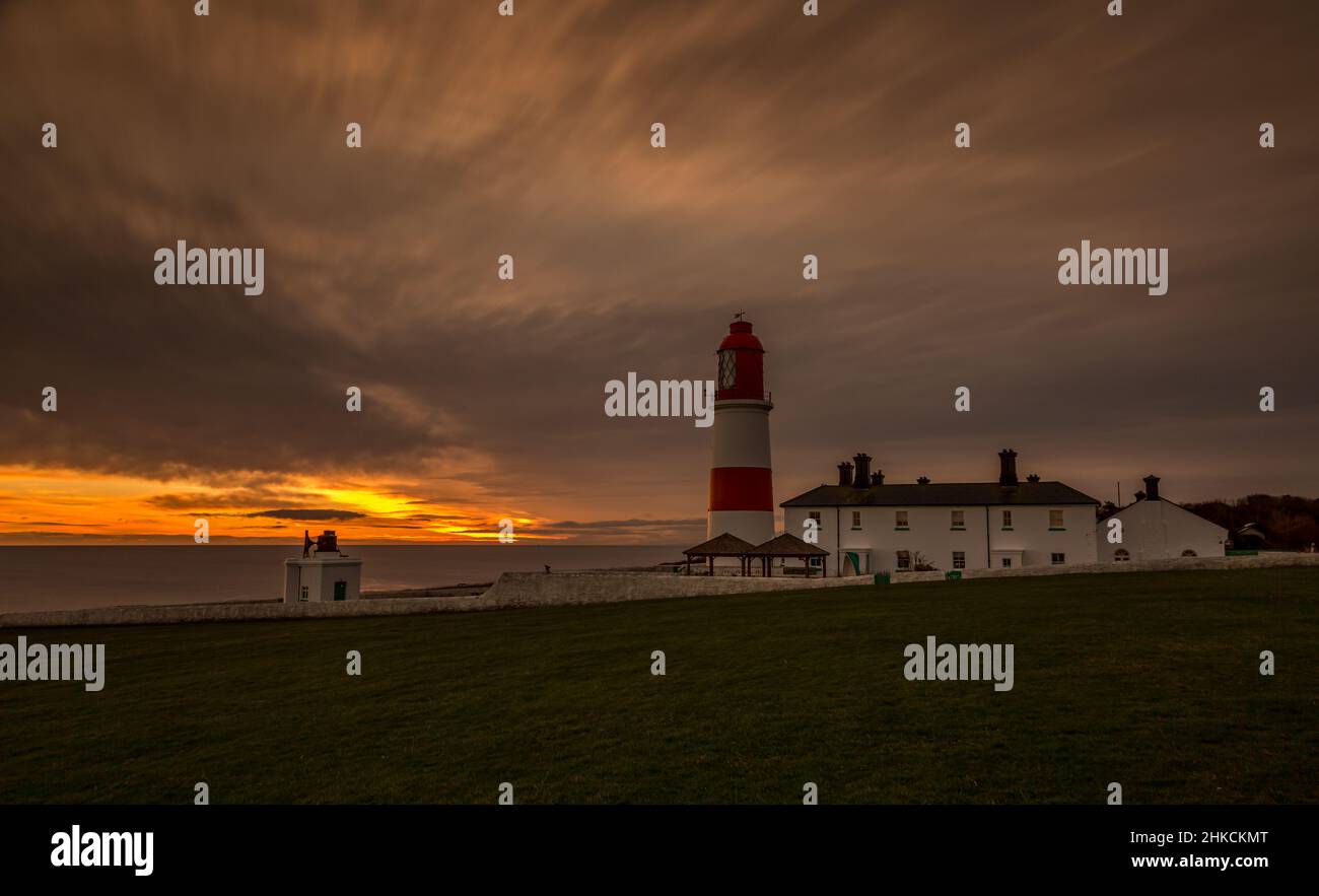 Le rouge et blanc rayé, 23 mètres de haut, le phare de Souter et les Leas à Marsden, South Shields, Angleterre, comme le soleil se lève Banque D'Images