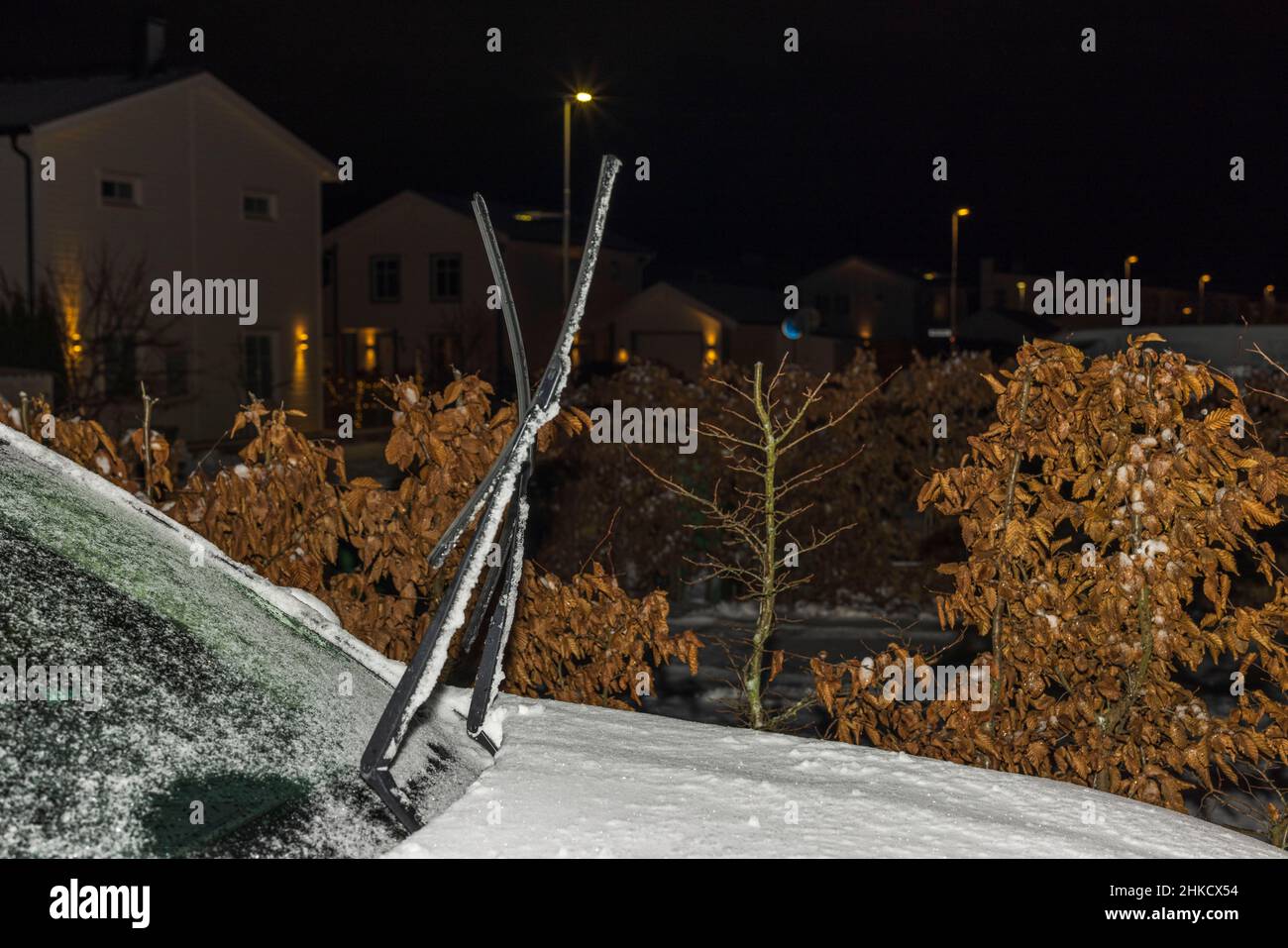 Vue de la voiture gelée avec les essuie-glaces surélevés pendant la nuit hivernale. Suède. Banque D'Images