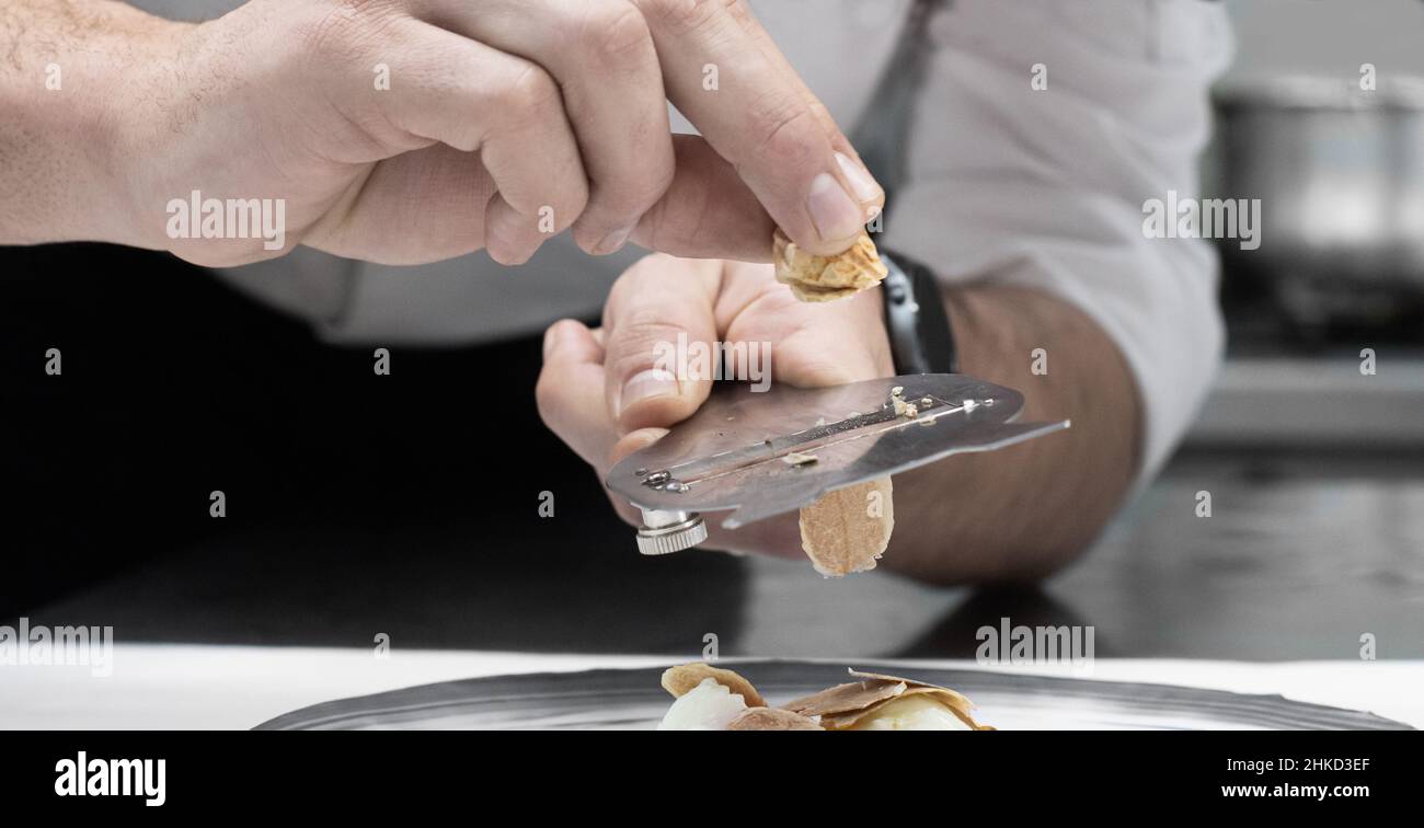 le chef coupe des tranches de truffe blanche dans le foyer sélectif de la cuisine Banque D'Images