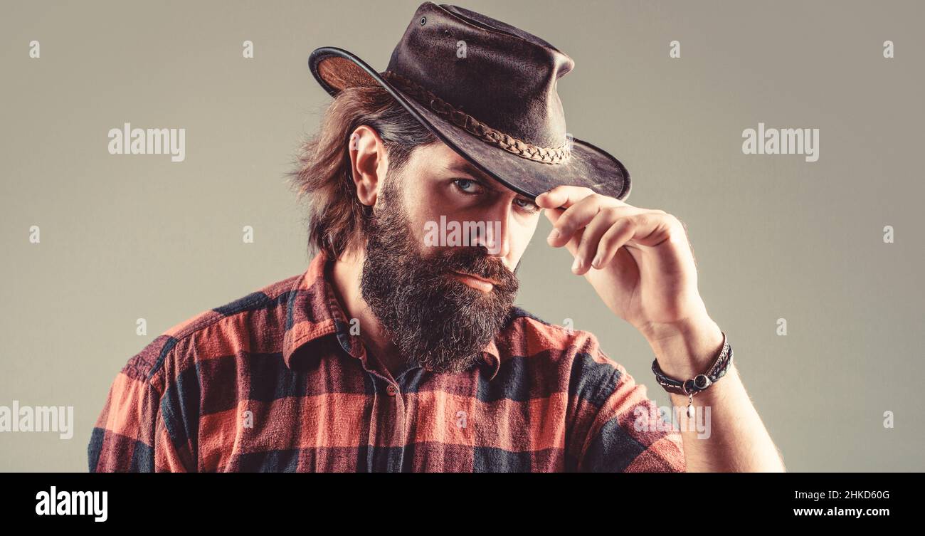 Cow-boys non rasés. Cow-boy américain. Chapeau de cowboy en cuir. Portrait d'un jeune homme portant un chapeau de cow-boy. Cowboys en chapeau. Jolie macho barbu Banque D'Images