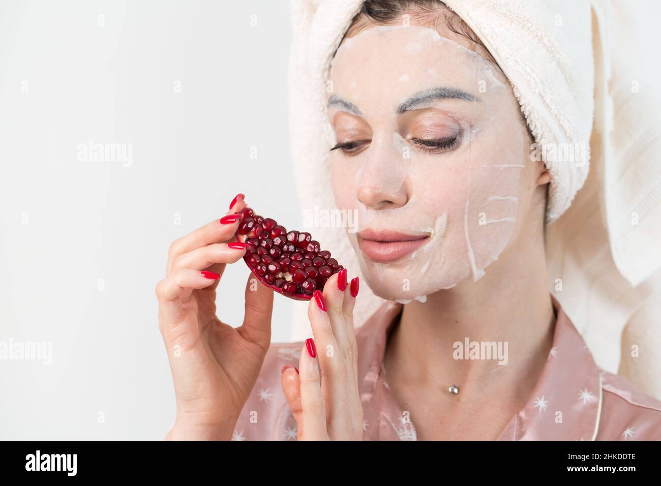 Soins du visage et soins de beauté.Femme avec une feuille de masque de  grenade hydratant sur son visage isolé sur fond blanc Photo Stock - Alamy