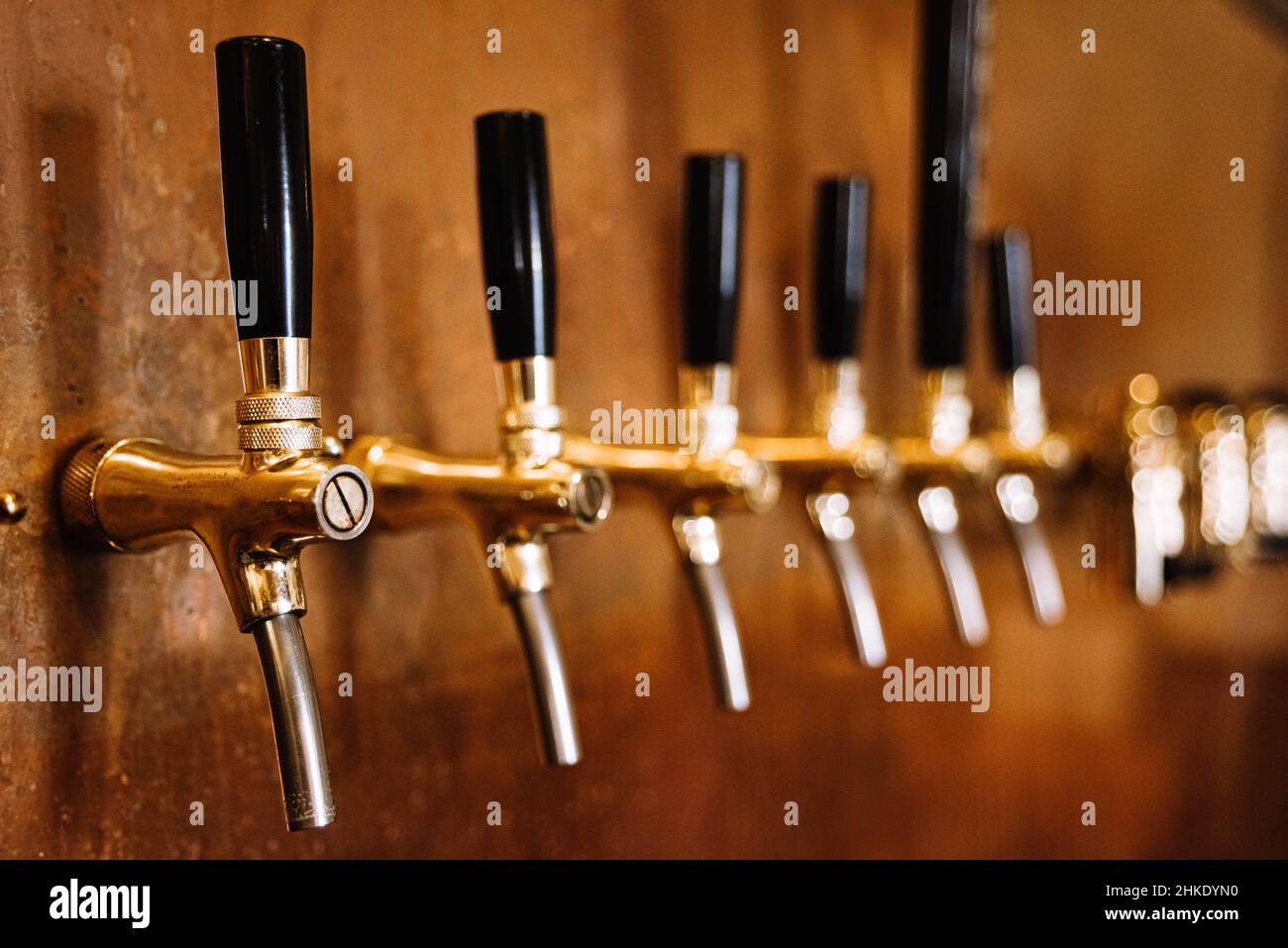 bière pression beaucoup dans une barre de rangée mur intérieur en cuivre Banque D'Images