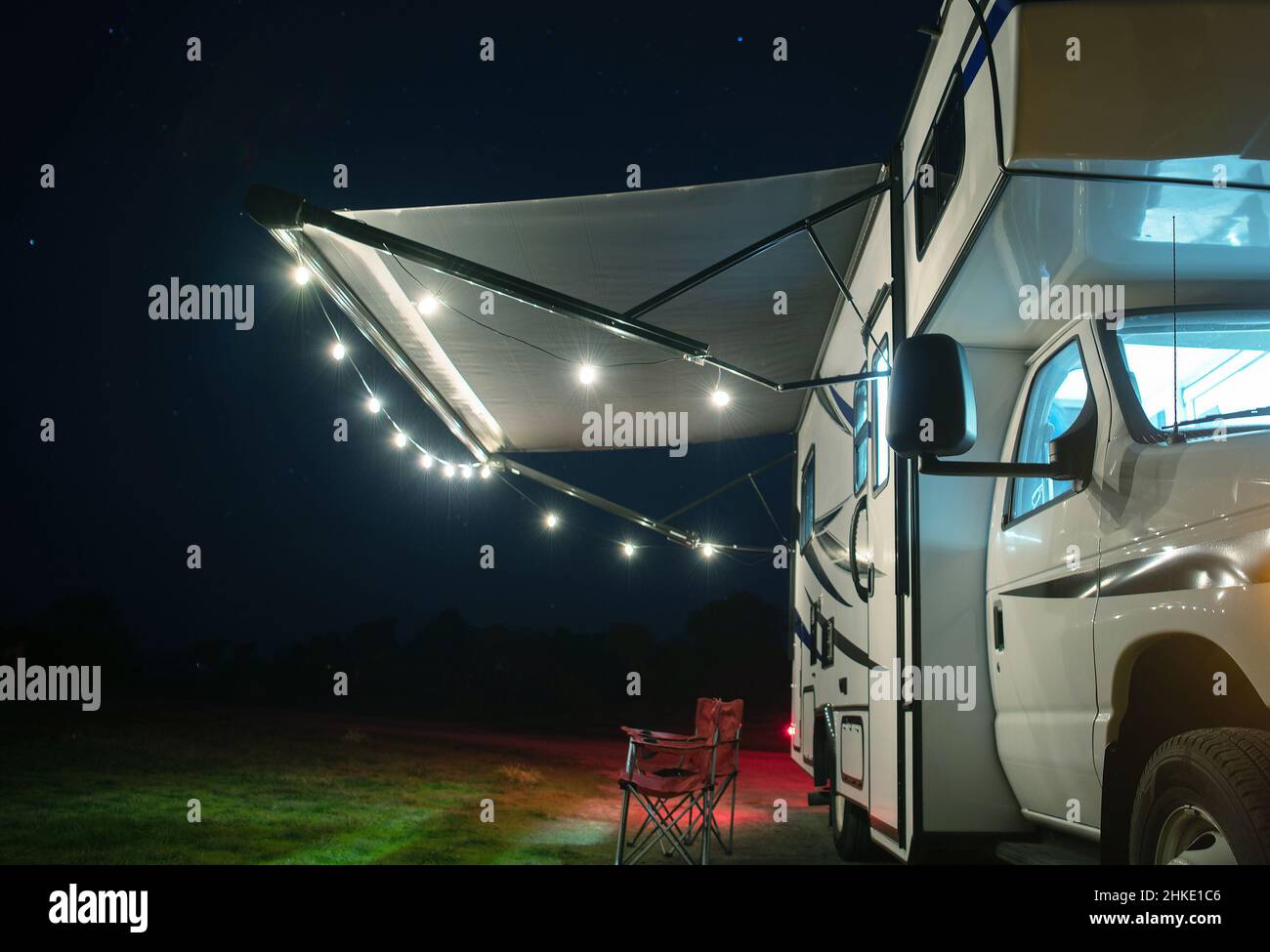 Confortable terrain de camping.Camping-car moderne classe C avec jeu de lumières sur l'auvent de camping-car.Véhicules récréatifs thème. Banque D'Images