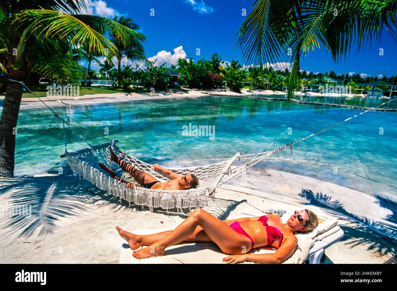 Les touristes se baignent dans des hamacs à la piscine de l'hôtel de station, Mactan Island, Cebu, Philippines Banque D'Images