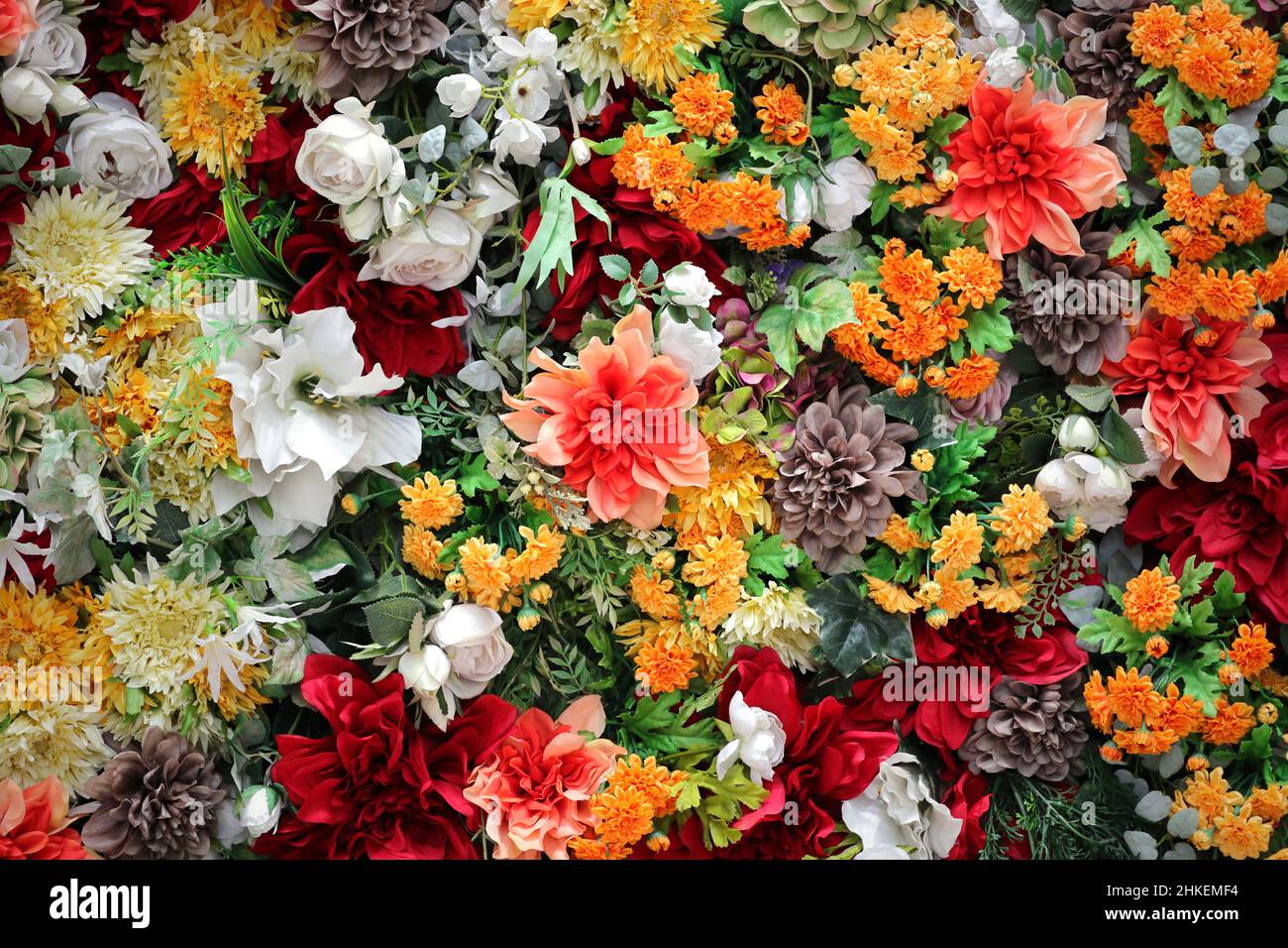 Photo pour le matériel de fond de mur coloré décoré avec beaucoup de fleurs artificielles Banque D'Images Photo pour le matériel de fond de mur coloré décoré avec beaucoup de fleurs artificielles Banque D'Images