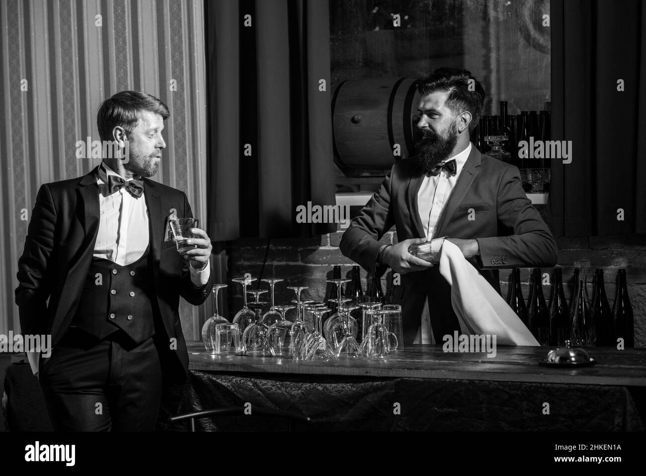 Barman barbu donnant une boisson à son client. Communication au pub. Service clientèle le week-end. Banque D'Images
