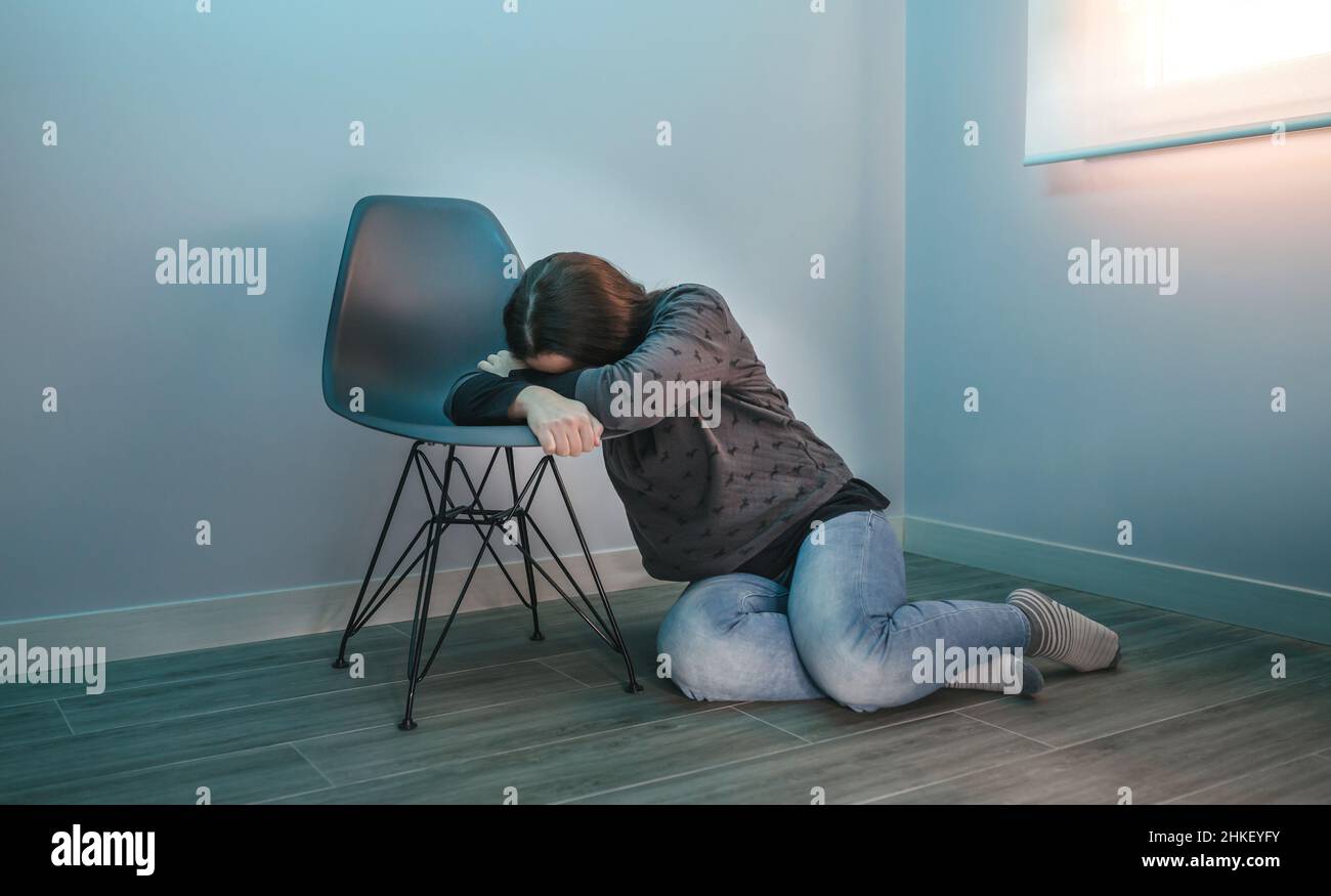 Femme dépressive qui pleure sur une chaise Banque D'Images