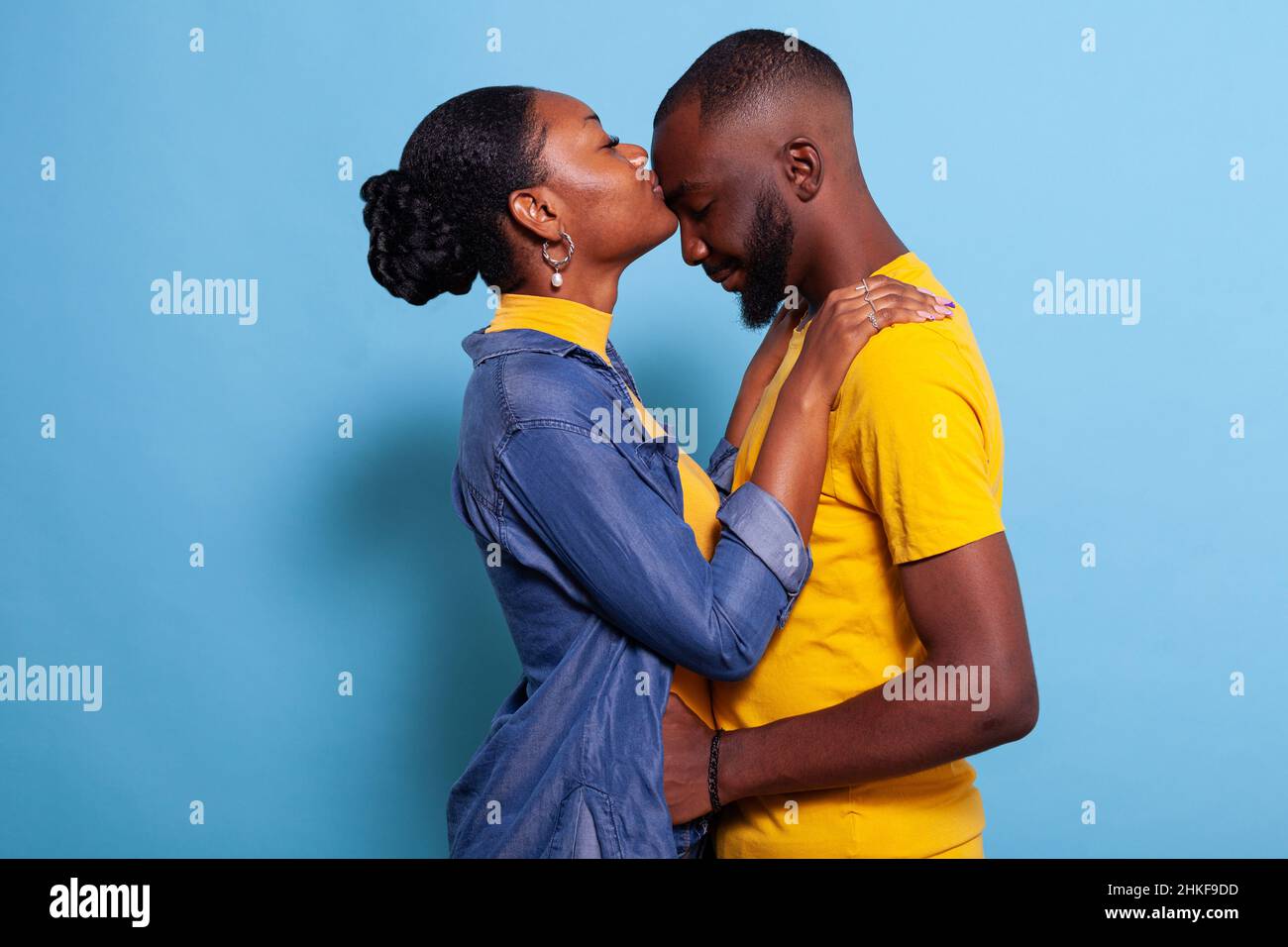 Femme donnant à un petit ami un baiser sur le front pour exprimer l'amour devant l'appareil photo.Les personnes en relation montrant l'affection et la passion avec embrasser et embrasser.Couple romantique avec des émotions heureuses. Banque D'Images