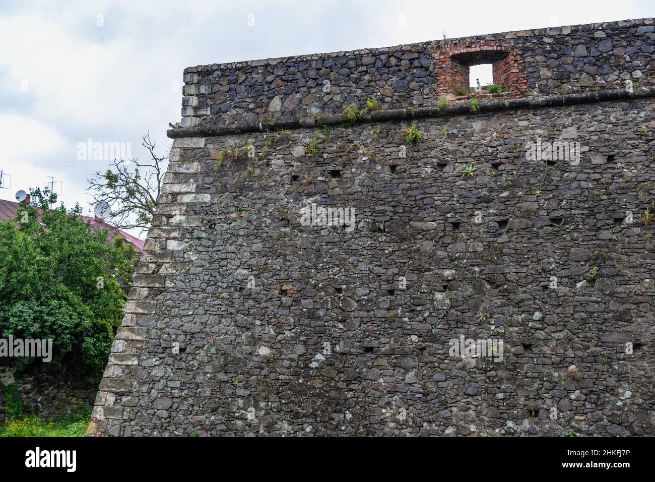 Mur médiéval du château gris de l'ancien château d'Uzhgorod avec une pelouse verte devant. Château d'Uzhgorod, région de Zakarpattya, Ukraine occidentale Banque D'Images