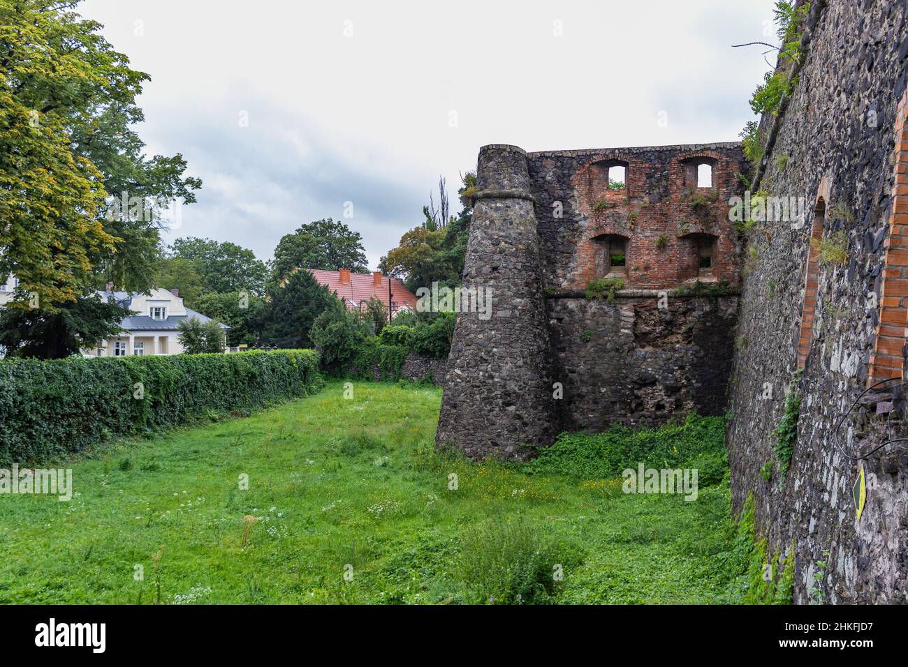 Mur médiéval du château gris de l'ancien château d'Uzhgorod avec une pelouse verte devant. Château d'Uzhgorod, région de Zakarpattya, Ukraine occidentale Banque D'Images