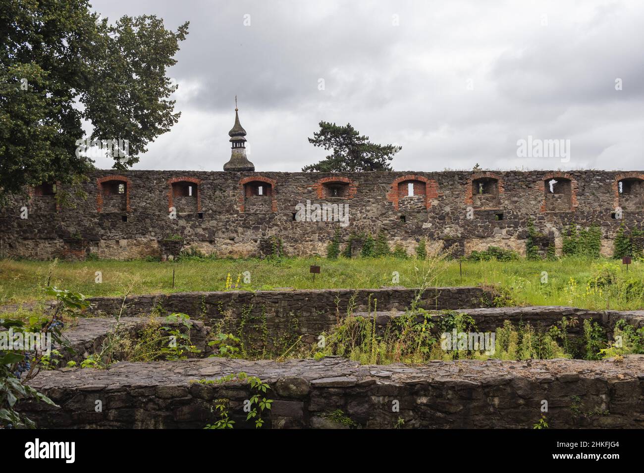 Mur médiéval du château gris de l'ancien château d'Uzhgorod avec une pelouse verte devant. Château d'Uzhgorod, région de Zakarpattya, Ukraine occidentale Banque D'Images