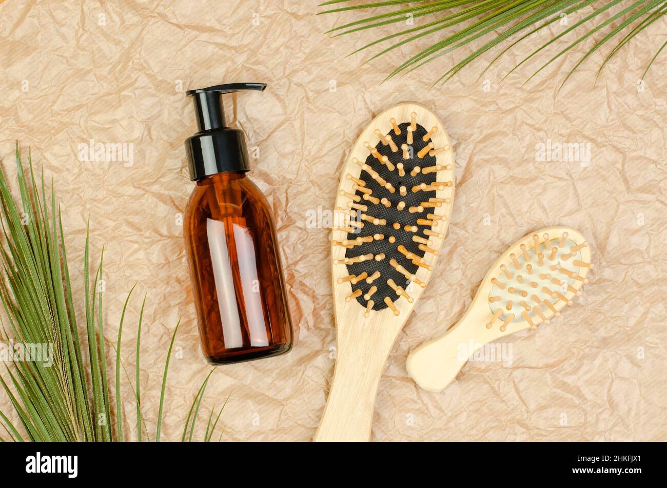 Brosses à cheveux et produits de soin des cheveux sur fond beige froissé. Banque D'Images