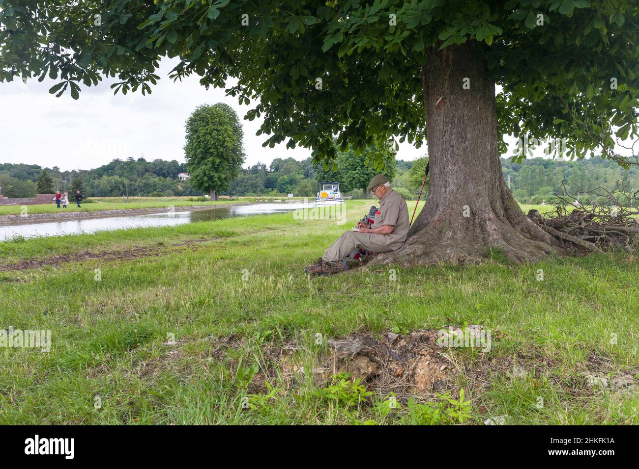 France, Loiret, vallée de la Loire classée au patrimoine mondial de l'UNESCO, route de la Loire à vélo, Loire à vélo, Briare, un randonneur griffonne son carnet Banque D'Images