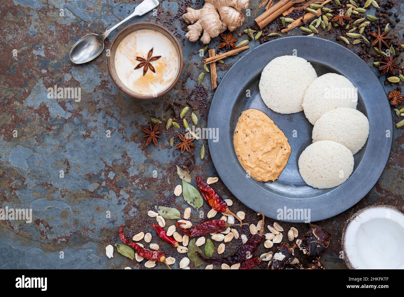 Idli maison, chutney épicé aux arachides et à la noix de coco avec une tasse de chai et des épices Banque D'Images
