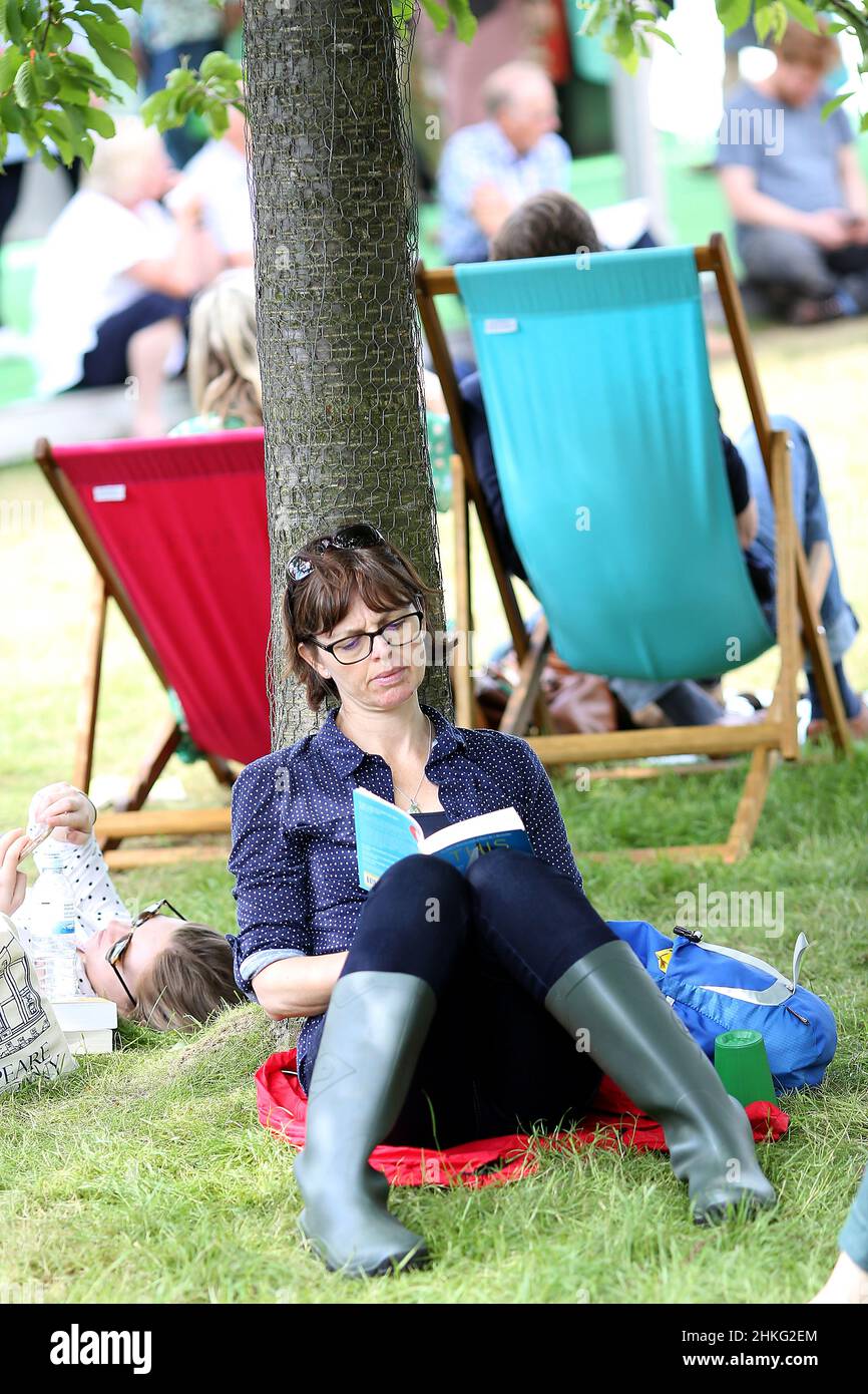 Hay Festival, une femme lit sous un arbre sur le vert le 2nd juin 2018. Banque D'Images