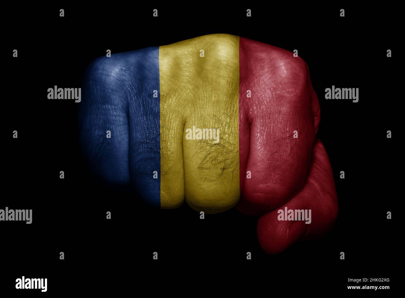 Drapeau de la Roumanie peint sur le poing fort sur fond noir Banque D'Images