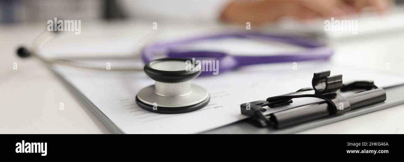 Stéthoscope violet situé sur des documents médicaux en gros plan Banque D'Images