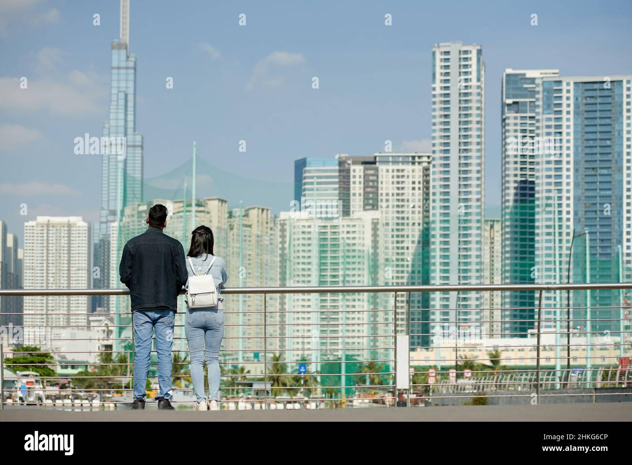 Jeune couple debout sur le pont et appréciant cityscane, vue de l'arrière Banque D'Images