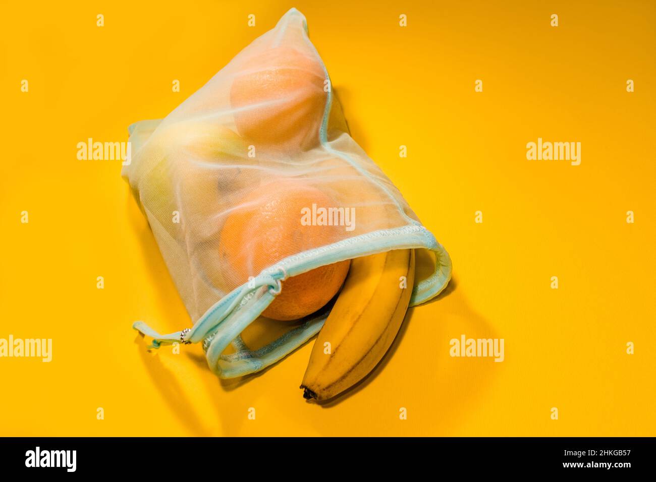 Fruits dans un sac jetable sur fond jaune. Banque D'Images