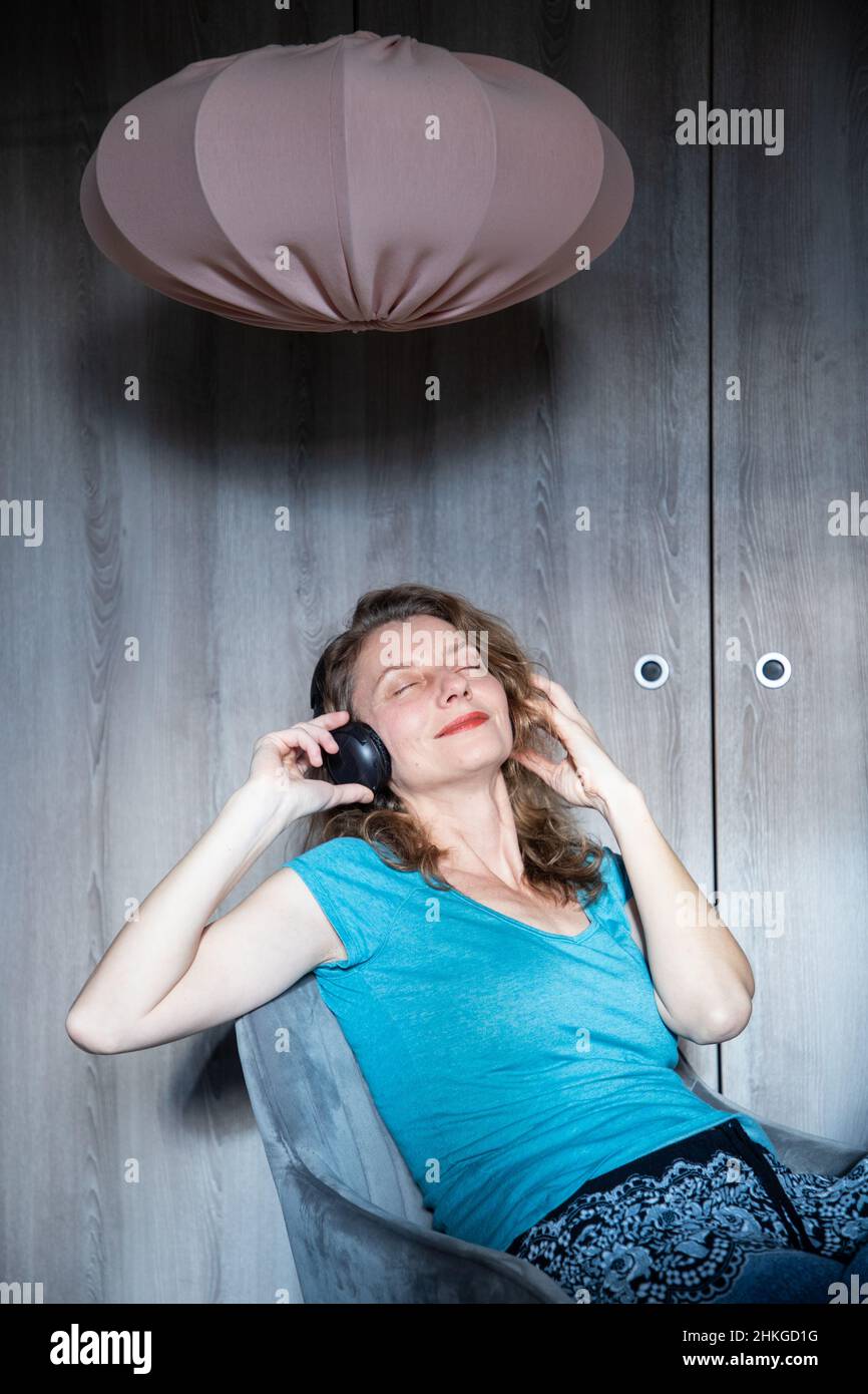 bonne femme détendue avec un casque qui écoute de la musique Banque D'Images