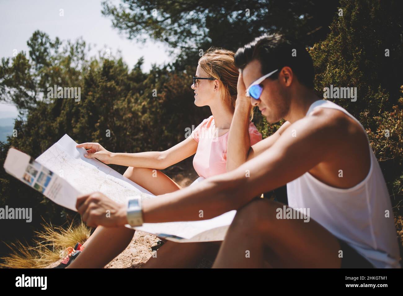 Couple étudiant la carte sur le sol par temps ensoleillé Banque D'Images