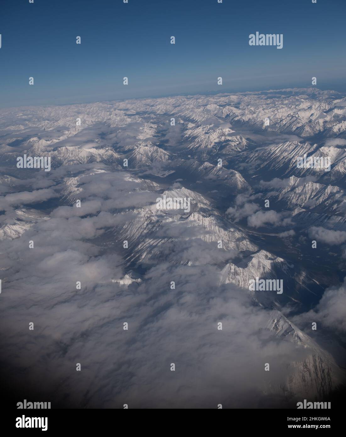 Vue sur les montagnes rocheuses enneigées du Canada entre l'Alberta et la Colombie-Britannique depuis le siège de fenêtre de l'avion lors d'hivers clairs vol de jour Banque D'Images