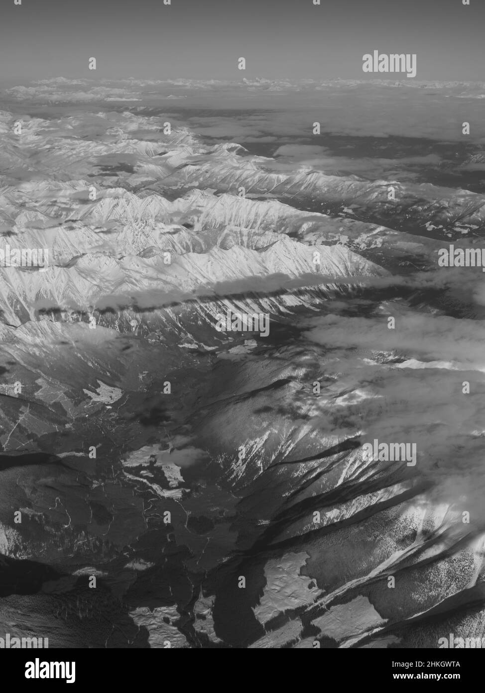 Vue sur les montagnes rocheuses enneigées du Canada entre l'Alberta et la Colombie-Britannique depuis le siège de fenêtre de l'avion lors d'hivers clairs vol de jour Banque D'Images