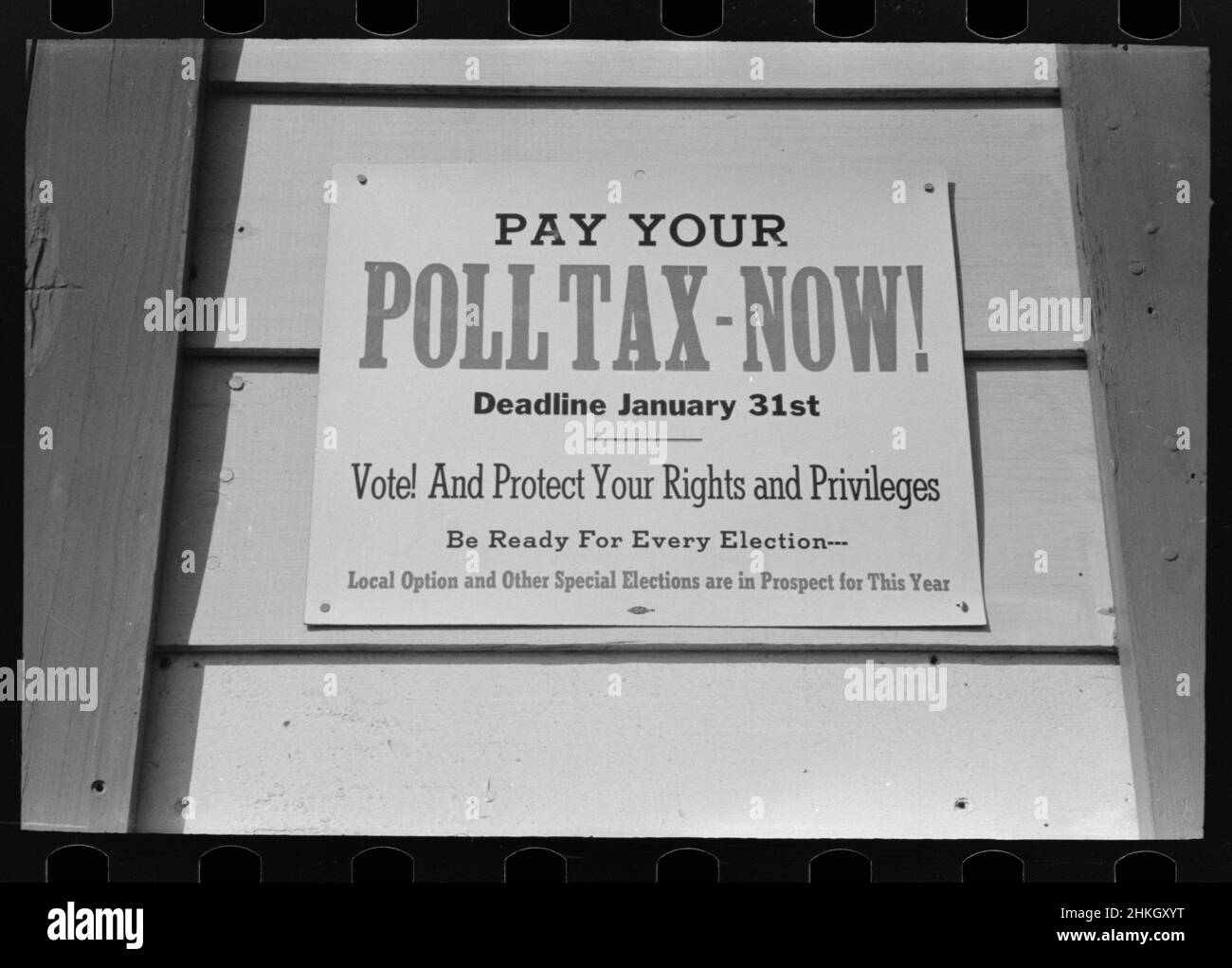 Affiche informative sur le côté d'une structure exhortant les électeurs à payer leur taxe de vote avant la date limite pour protéger leurs droits de vote et privilèges, Mineola, Texas, 1/1943.Photo de Lee Russell Banque D'Images