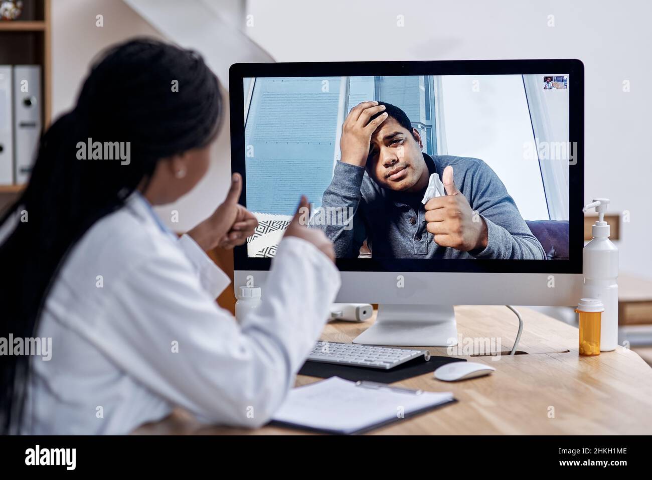 Merci pour votre aide, doc. Photo d'un jeune homme montrant les pouces vers le haut pendant un appel vidéo avec un médecin sur un ordinateur. Banque D'Images