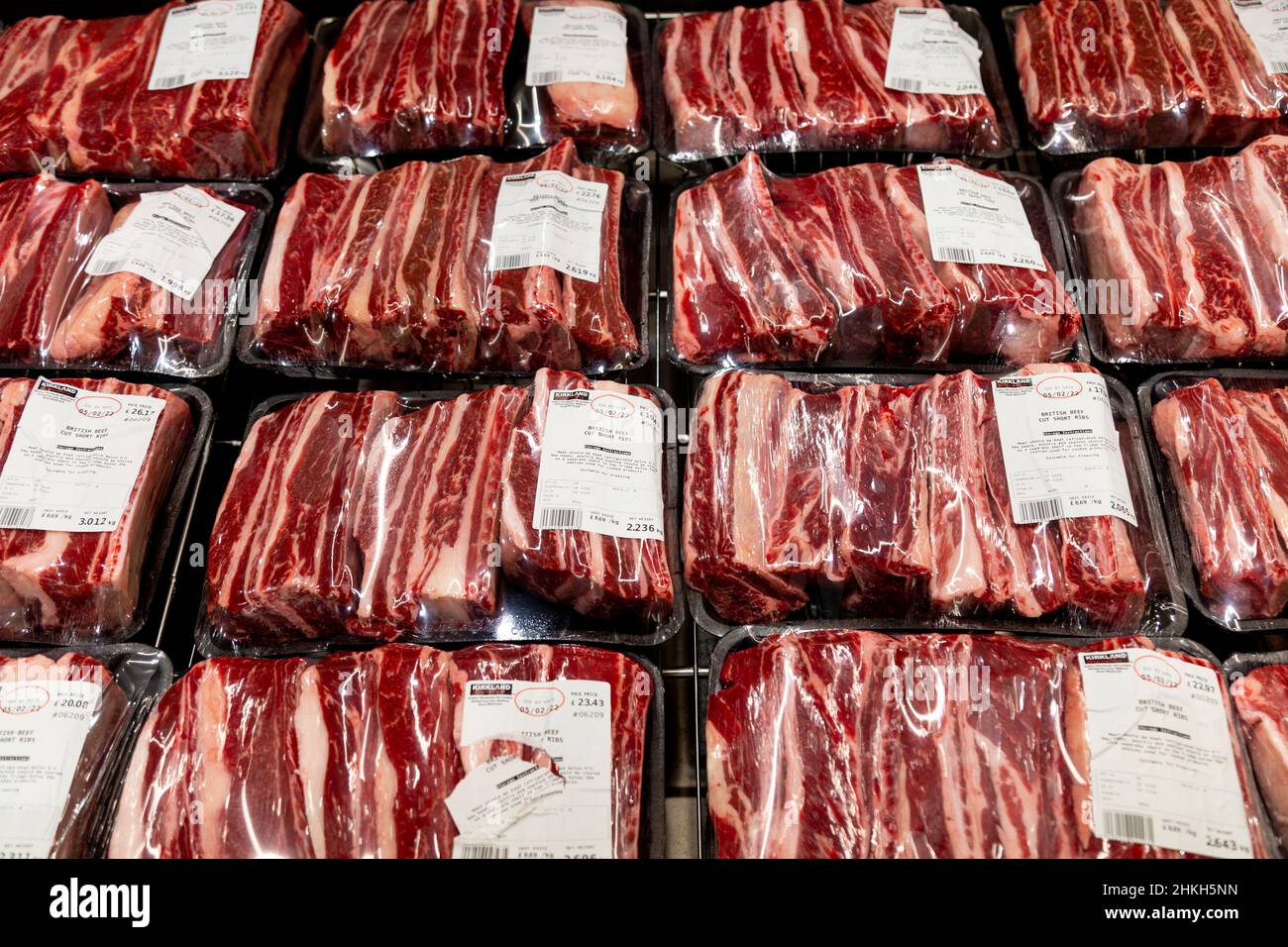 Paquets de côtes enveloppées dans du plastique, de la viande rouge dans un réfrigérateur de supermarché Banque D'Images